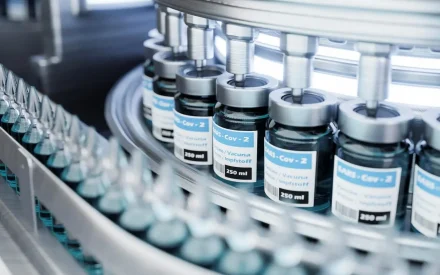 Automated pharmaceutical production line filling vaccine vials in sterile environment for cold chain storage and distribution